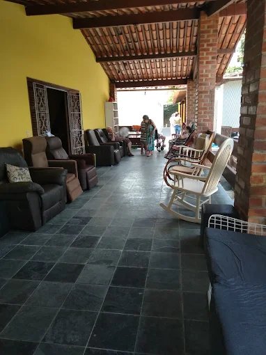 Ampla sala de convivência com sofás e cadeiras de balanço